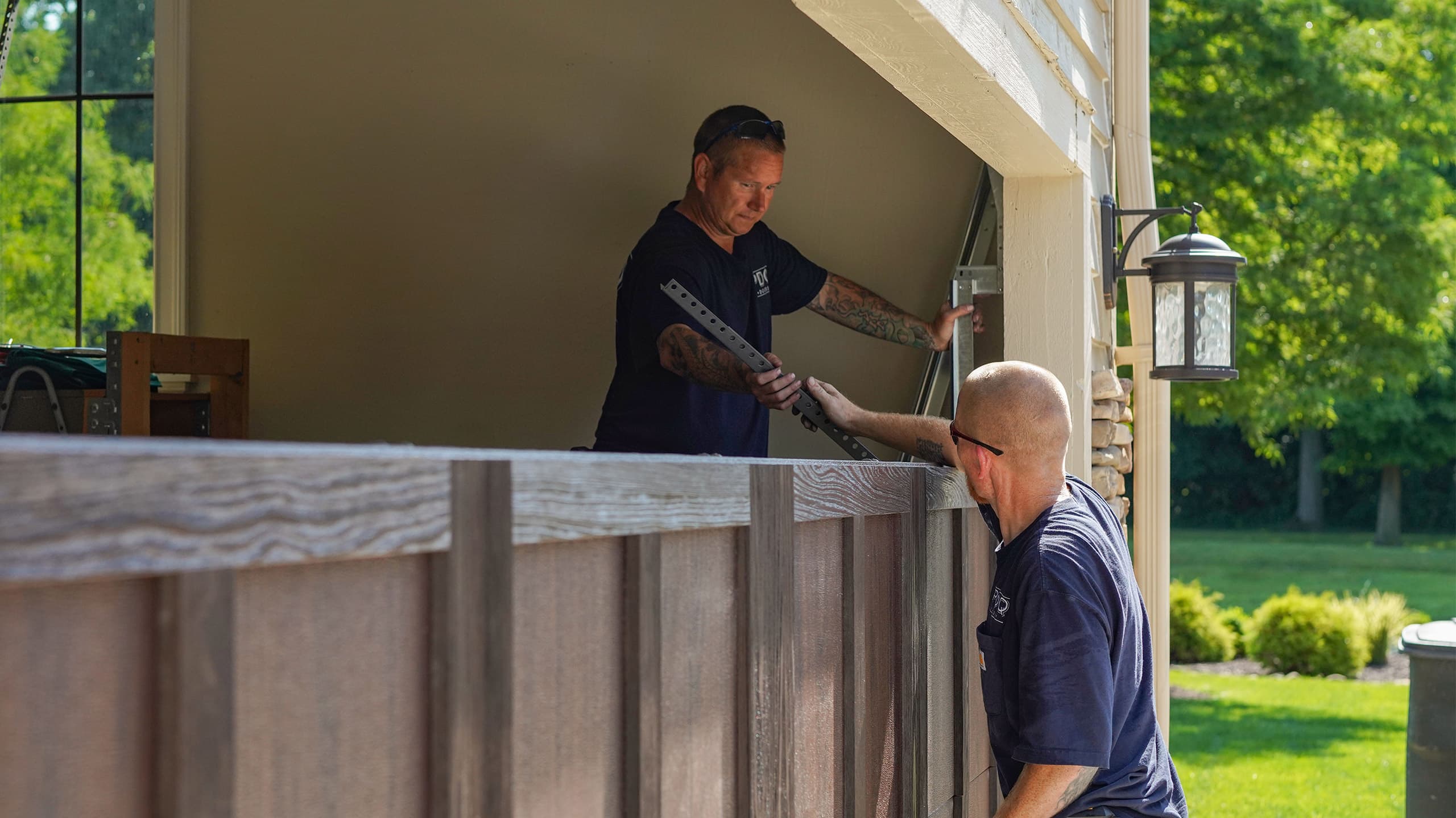 PDQ Doors technicians installing a new garage door at a residential home