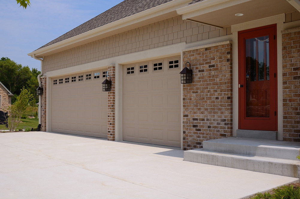 A house with a tan two car traditional garage door