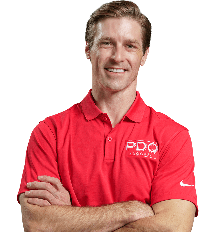 A smiling man wearing a red polo shirt with the PDQ Doors logo embroidered on the front